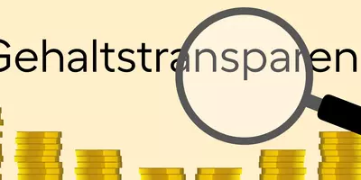 Eine Lupe, die auf das Wort "Gehaltstransparenz" zeigt.
